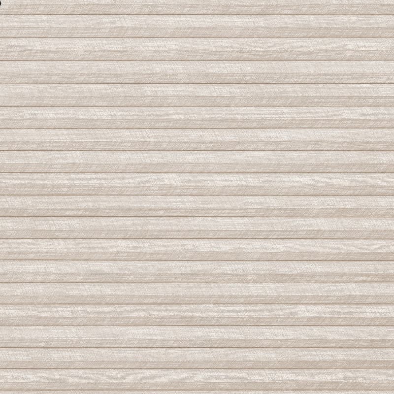 Beige pleated cellular blind covering entire frame, fully lowered and closed with horizontal folds; filtering soft diffuse indoor light against a textured fabric surface.