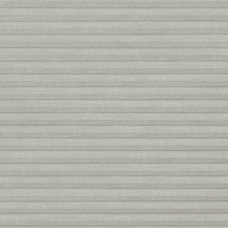Light-gray pleated cellular shade, fully lowered with textured horizontal folds; closed, blocking view and softly diffusing daylight; fills a neutral, minimally lit interior wall with uniform, muted tone.