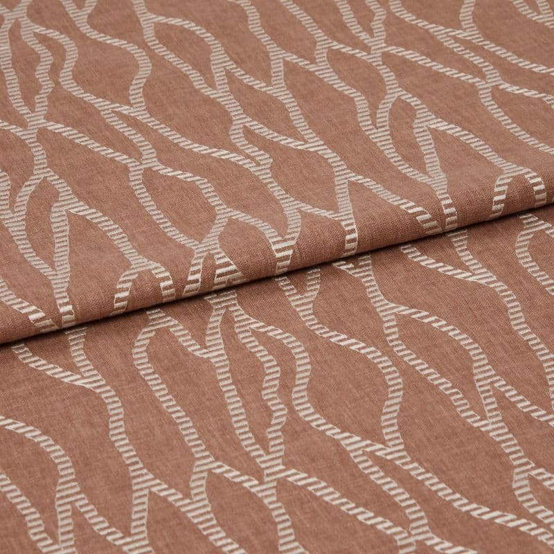 Folded terracotta-brown fabric with raised white embroidered undulating chain pattern, folded over itself with a horizontal overlap, close-up studio view emphasizing woven texture and soft, even lighting.