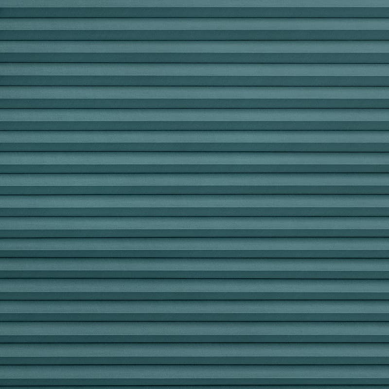 Teal horizontal pleated blinds, fully closed with textured fabric and narrow even folds; filtering soft, diffuse light; close-up interior view with neutral lighting and no visible window frame.