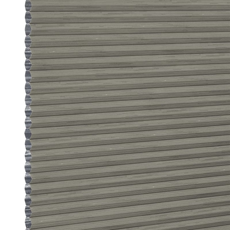 Grey cellular (honeycomb) pleated blind, fully lowered with visible hexagonal side cells, blocking light; close-up view showing textured fabric and narrow horizontal pleats, plain neutral background.