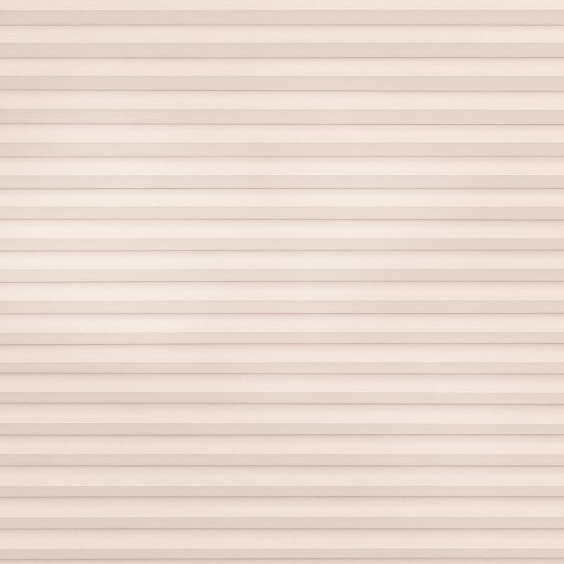 Beige pleated cellular blind covering the entire window, horizontal folded slats tightly closed; filtering soft, even daylight into a neutral interior with no visible frame or outside view.