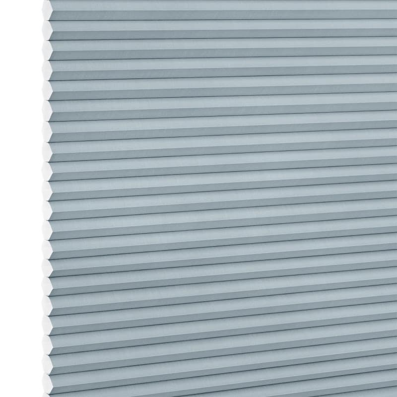 Light-blue cellular (honeycomb) blind, fully lowered with horizontal pleats and hexagonal cells visible at the left edge; blocking light in a close-up view against a white background.