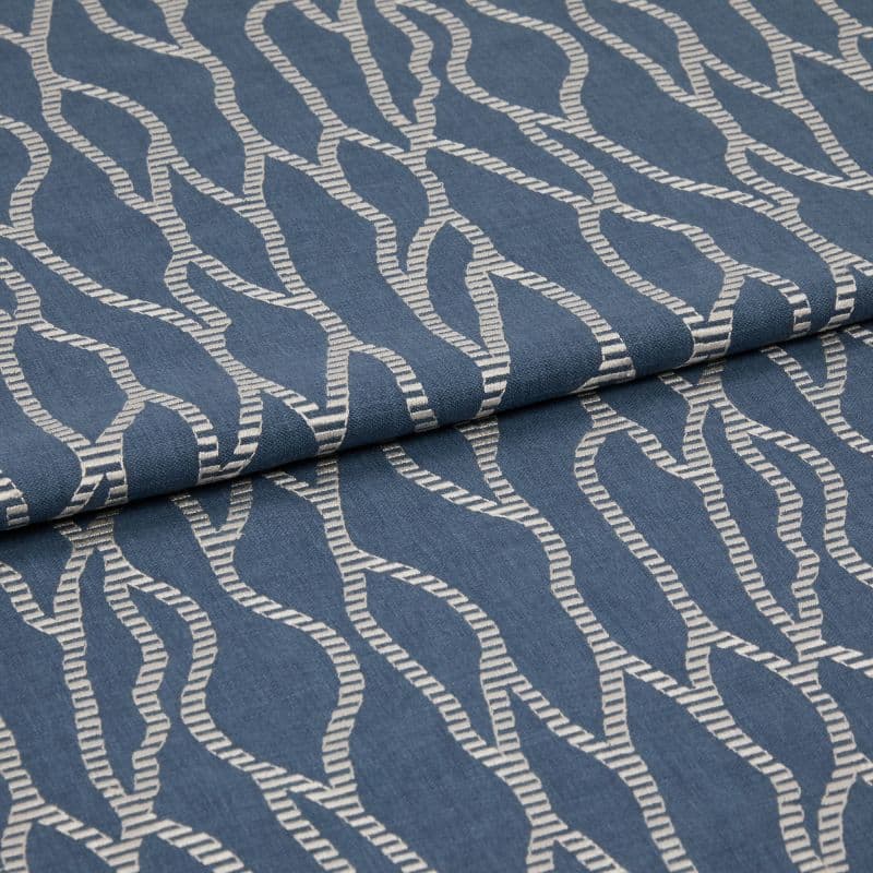 Blue woven fabric with cream embroidered wavy rope pattern, folded over itself, shown in a close-up studio view with soft, even lighting.