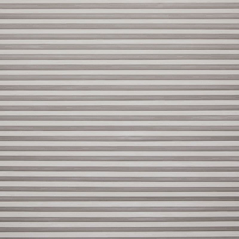 Horizontal slatted roller shutter (narrow, textured beigeâ€‘gray metal slats) â€” fully closed, overlapping â€” blocking light and view across a window or doorway in neutral indoor lighting.