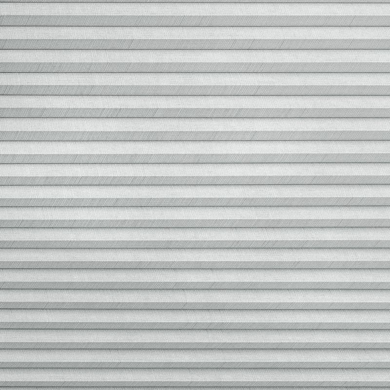 Horizontal pleated (cellular) blind, fully lowered with regular narrow folds and textured fabric, blocking the view and softly diffusing daylight in a neutral, evenly lit interior.