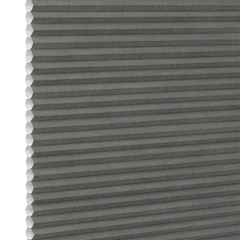 Gray cellular (honeycomb) pleated blind, fully lowered and closed, blocking light; close-up interior view showing textured fabric and white left-side gap under neutral lighting.