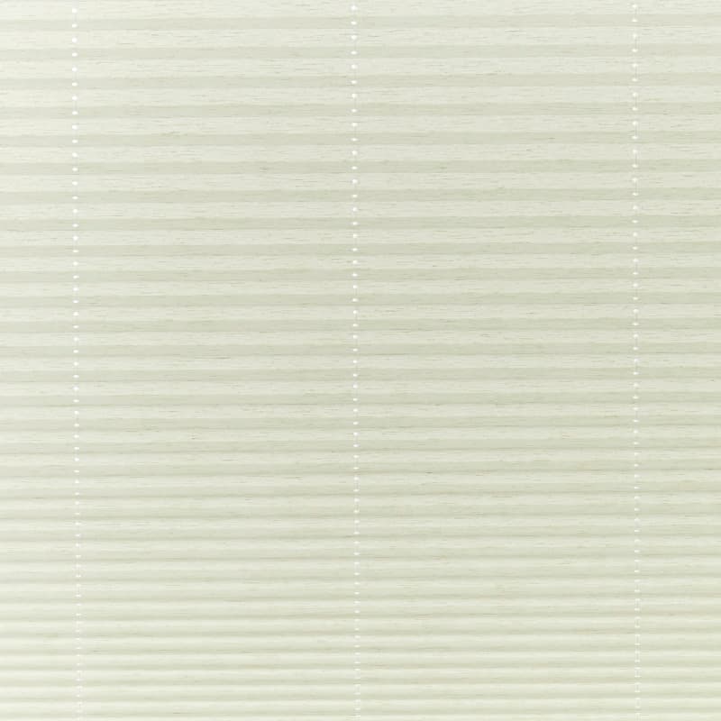 Cream cellular pleated blinds covering the window, closed and gently filtering soft daylight; three faint vertical cord lines with small white grommets, neutral interior lighting.