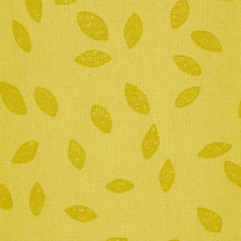 Yellow woven curtain panel, hung flat and showing scattered darker-yellow leaf motifs on a coarse textured weave; close-up interior textile detail, evenly lit with no visible window.
