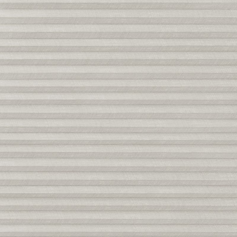 A closed light-gray pleated cellular blind with subtle linen texture, filtering and diffusing light evenly, covering a window within a neutral, softly lit interior.