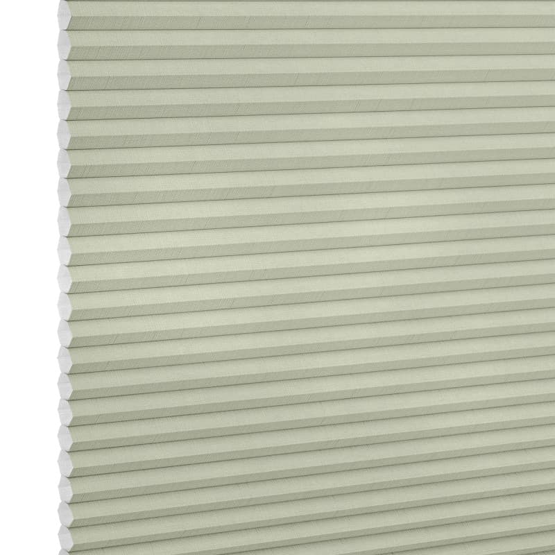 Cellular honeycomb blind, pale sage, fully lowered with visible hexagonal cells at left, blocking light; close-up product shot against a neutral white background with soft, even lighting.