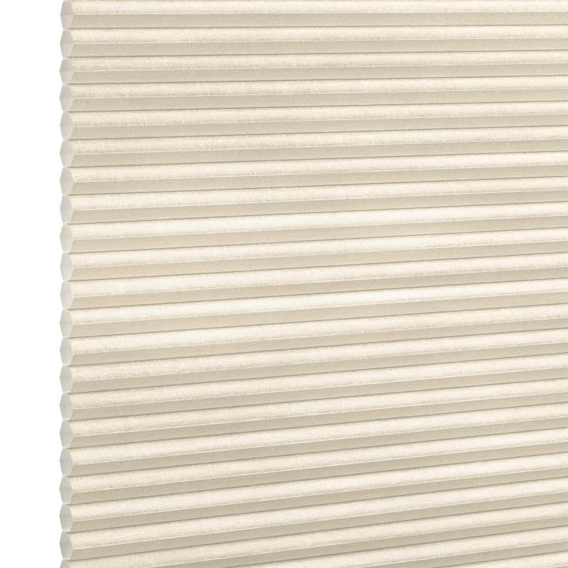 Beige honeycomb (cellular) blind, fully lowered with horizontal pleats and visible cells; closed and softly diffusing daylight; set against a neutral white-lit background with no visible room or view.