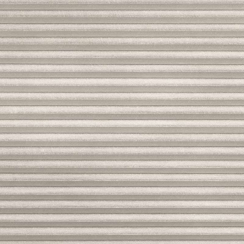 Beige pleated cellular shade, textured fabric with narrow horizontal folds, fully lowered and closed; filtering diffuse light into a neutral, softly lit interior space with no visible view.