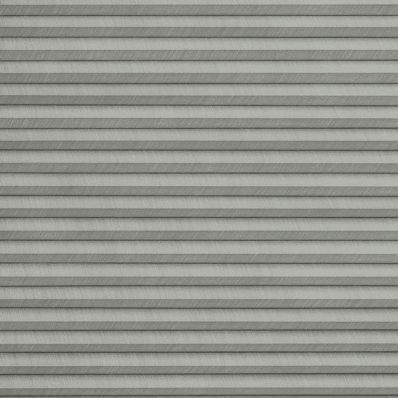 Grey pleated cellular blinds across the frame, closed with uniform horizontal folds and textured fabric; blocking view and softly diffusing light in a neutral, minimally lit interior.