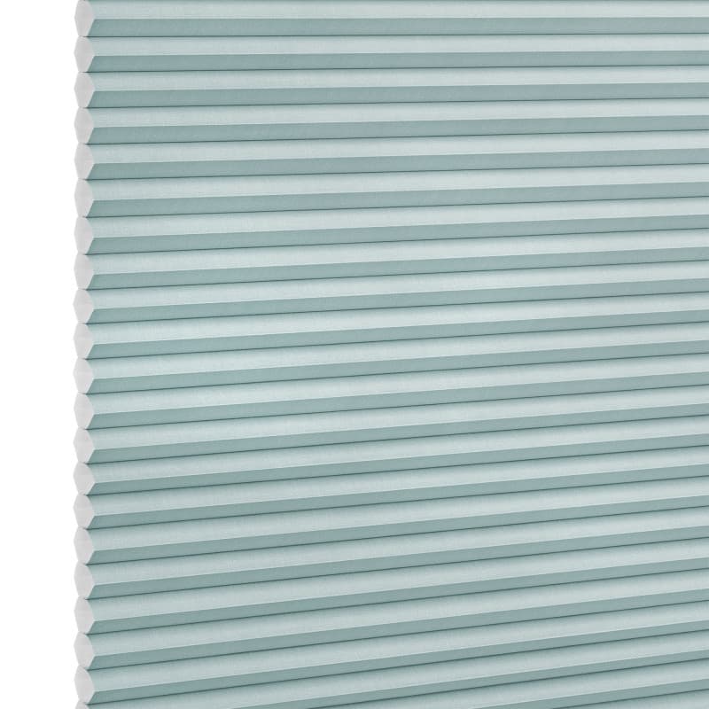 Honeycomb (cellular) shade, light-teal horizontal pleats, fully lowered; closed, softly diffusing light; close-up studio view against a white background.