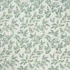 Cream wallpaper patterned with repeating teal leafy vine motifs, decorating and covering a wall; subtle texture and soft, evenly lit interior context suggesting a classic, botanical room décor.