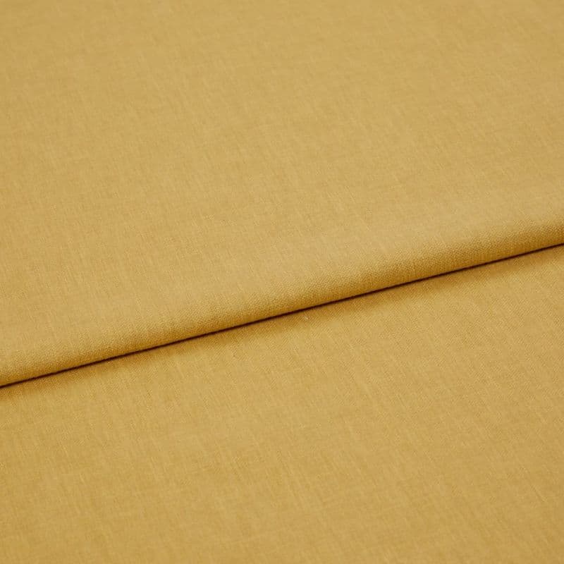 Mustard-yellow woven fabric panel, folded once with a visible overlapping edge, lying flat and smooth; close-up, studio-lit view emphasizing fine textile texture and warm, even lighting.