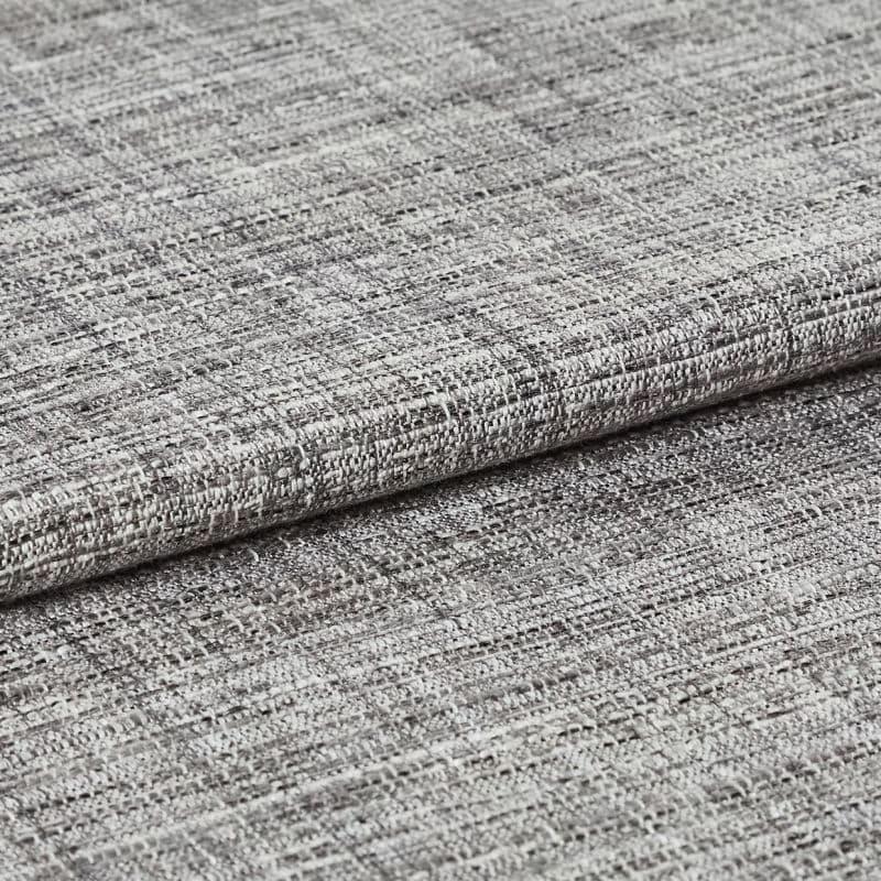 Woven grey curtain fabric folded into overlapping horizontal layers, showing coarse, irregular weave; tight close-up with neutral lighting highlighting texture and subtle tonal variation.