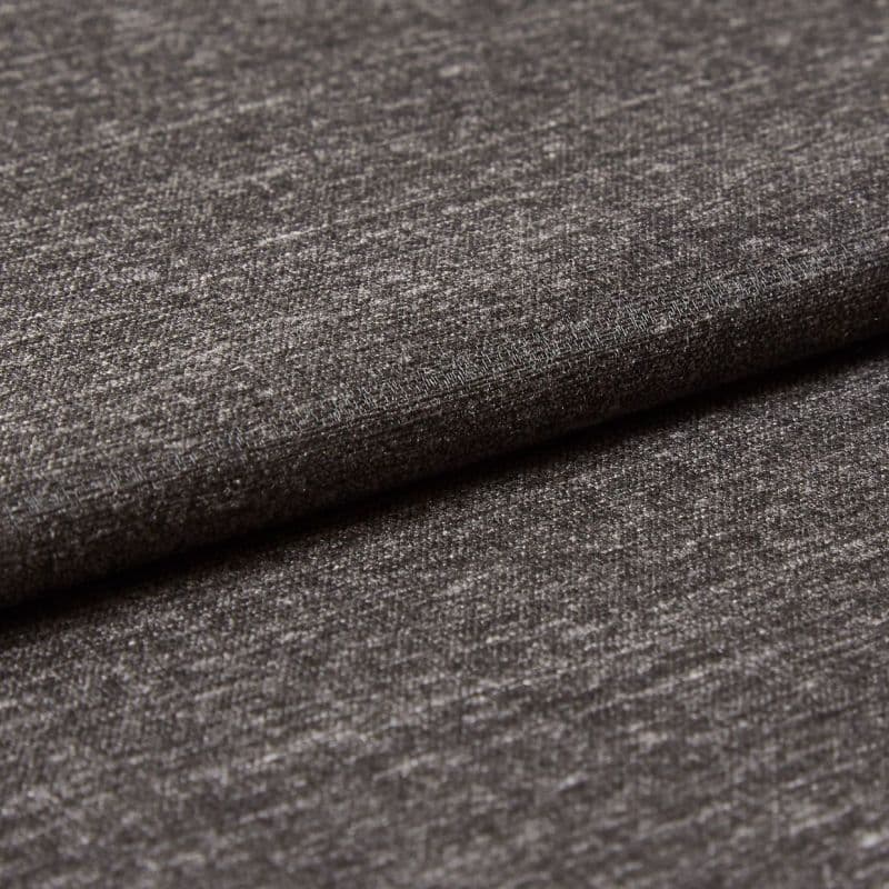 Dark gray woven upholstery fabric, folded with an overlapping edge, showing subtle metallic sheen and fine horizontal texture; close-up view under soft studio lighting against a neutral backdrop.