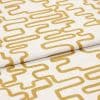 A folded linen-like curtain fabric with mustard-yellow continuous rounded-rectangle print; folded and lying flat, photographed close-up under soft studio lighting showing texture and repeating geometric pattern.