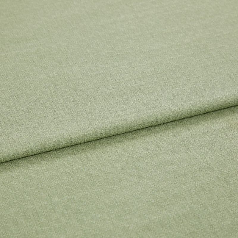 Pale green woven fabric folded once, showing a horizontal overlap and subtle textured weave; lying flat in soft, even studio lighting with a neutral background.