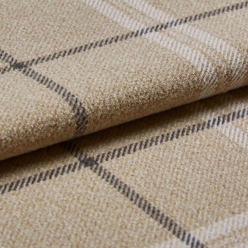 Beige wool plaid blanket with thin dark and white checks, folded in layers; resting on a matching fabric surface; close-up shot emphasizing textured fibers and soft, diffuse lighting.