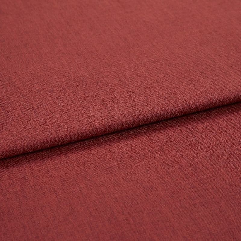 A folded red-brown woven upholstery fabric, folded once across the frame; fine, even weave visible, shown in close-up with soft, even studio lighting.