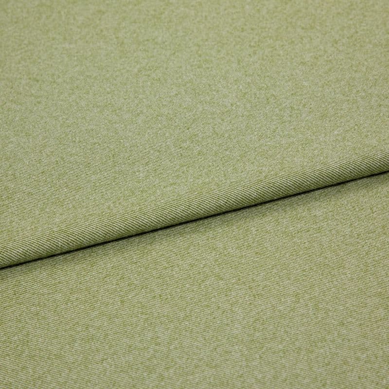Green woven fabric (upholstery-like) folded diagonally, showing fine twill texture; layered fold creates a shadowed seam across the frame against a neutral, evenly lit background.