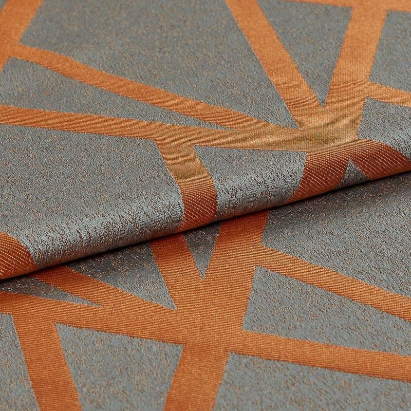 Woven gray-blue fabric with wide rust-orange geometric stripes, folded and overlapped; textured, slightly metallic sheen visible under soft studio lighting in a close-up view.