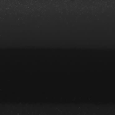 Star-speckled black sky — tiny points scattered unevenly — with a faint horizontal mid-band and indistinct dark horizon suggesting a dim, minimalist nocturnal scene.