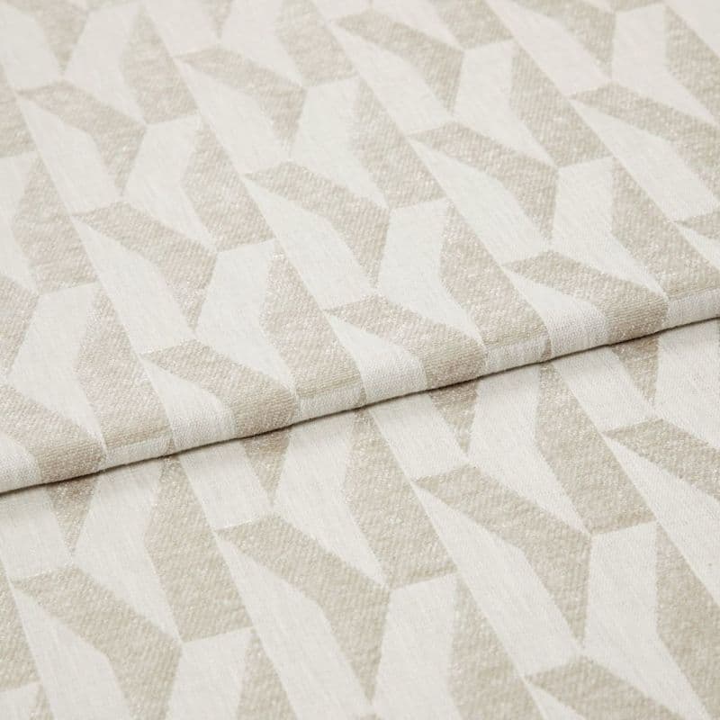 Beige-and-ivory geometric woven fabric with repeating angular, three-dimensional pattern; folded over itself, showing texture and slight sheen; studio-lit close-up on a neutral background, suited for upholstery or curtains.