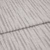 Patterned upholstery fabric (folded), pale mauve vertical dash stripes and textured weave; overlapping folded edge across the frame; close-up on a flat surface under soft, neutral lighting.