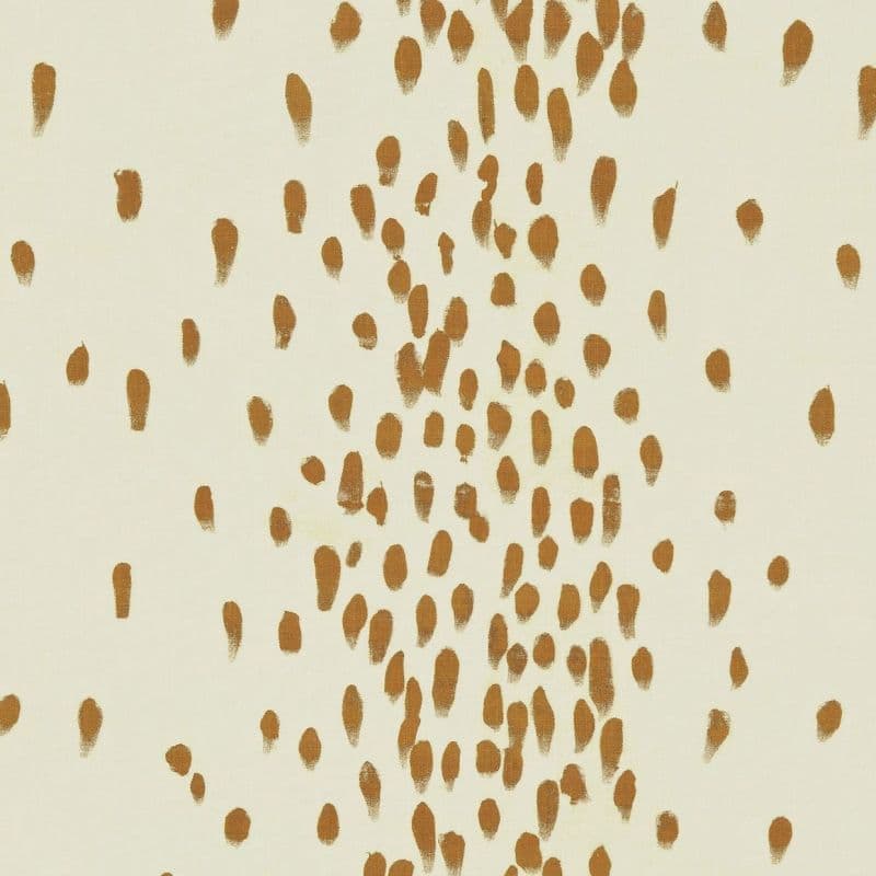 Ochre brushstroke dabs across a cream surface; hand-painted dots clustered densely in a vertical band and sparser toward edges; presented as a minimalist wallpaper or textile pattern in neutral lighting.