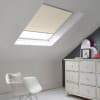 Room with white eaves wall, dark blue-grey wall to right with a shabby chic white drawer unit, a contemporary white chair, white painted floorboards and a skylight blind in cream.