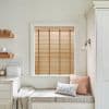 Wooden horizontal blinds with vertical tapes across the face, fully lowered and mostly closed, filtering warm daylight in a pale kitchen window-seat nook with cushions.
BREAD