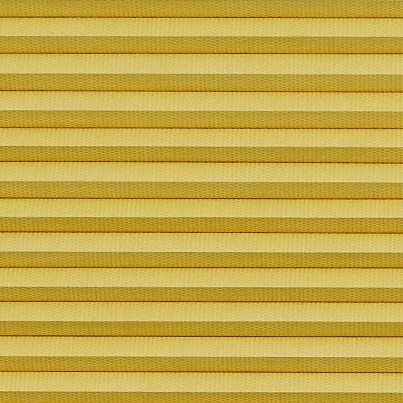 Horizontal cellular (honeycomb) pleated blind, closed with evenly spaced golden-yellow fabric folds and subtle texture; blocking light and insulating, filling the frame under warm diffuse lighting.