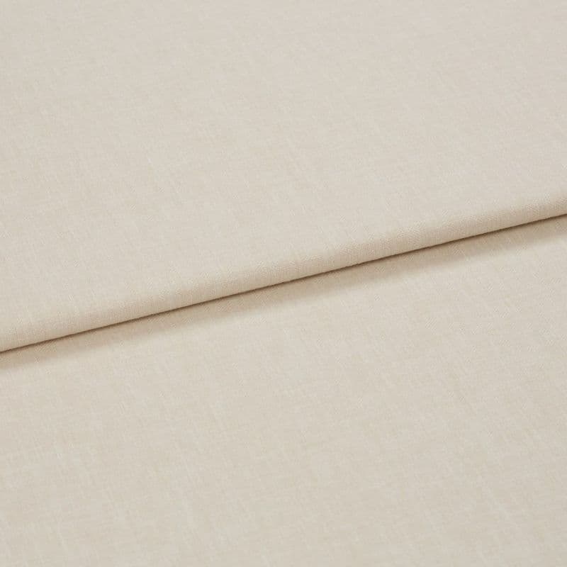 Beige woven curtain-like fabric panel with a clean horizontal fold (overlapping layer); lying flat on a neutral surface; close-up, soft diffuse lighting.