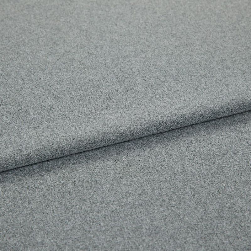 Grey, fine-textured upholstery fabric folded in overlapping layers; tightly woven, slightly napped surface. Close-up view on a flat, neutral background with soft, even lighting emphasizing texture.
