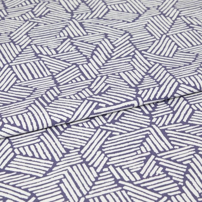 Folded fabric with purple background and white hand-drawn diagonal stripe hexagon pattern; the cloth is folded once with a visible overlap; close-up on a flat surface under even studio lighting.