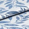 Folded woven fabric with raised blue leaf jacquard pattern; folded and overlapping, revealing textured weave and subtle sheen; close-up product-style shot with soft, neutral lighting suggesting upholstery or curtain material.