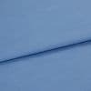 Blue woven fabric, folded with a horizontal overlap and visible fine weave; laid flat on a neutral surface under soft, even lighting in a close-up studio view.