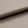 Beige tightly woven upholstery fabric, folded with an overlapping edge across the frame, revealing a pebble-like weave; close-up macro view with soft neutral lighting and plain background.