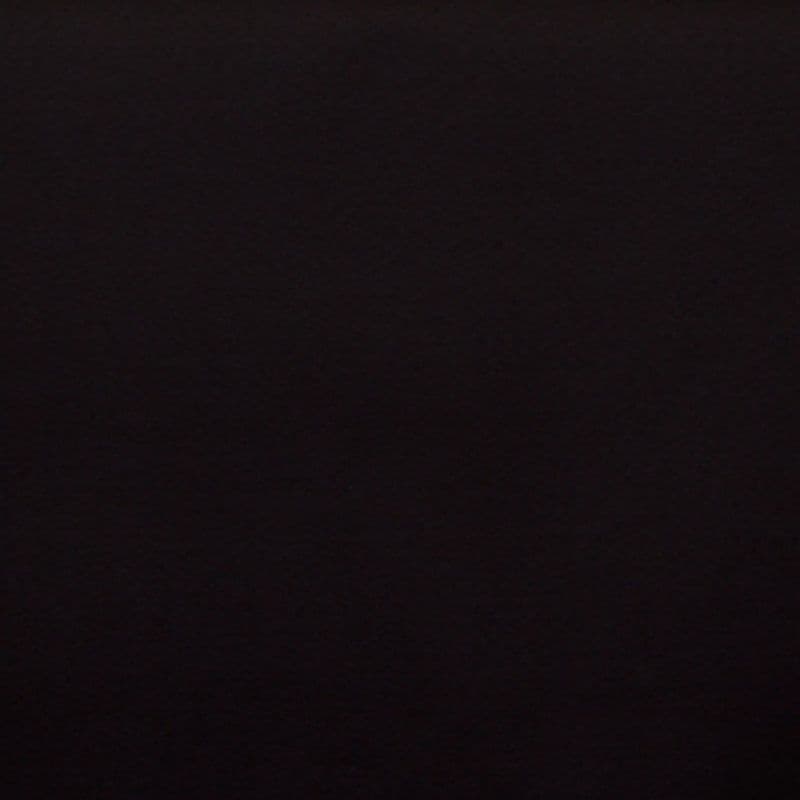 Matte dark wall centered in frame, flat and featureless; absorbing light and appearing unlit; context: dim indoor scene with no visible details or furnishings.