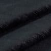 Black plush faux-fur fabric folded into two horizontal ridges, dense short pile and velvety nap; folds cast soft shadows in a close-up, evenly lit studio view.