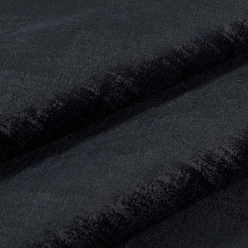 Black plush faux-fur fabric folded into two horizontal ridges, dense short pile and velvety nap; folds cast soft shadows in a close-up, evenly lit studio view.