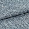 Blue-gray woven fabric swatch with irregular white flecks — folded and overlapped — close-up studio view with even lighting, emphasizing coarse looped weave and subtle color variation.