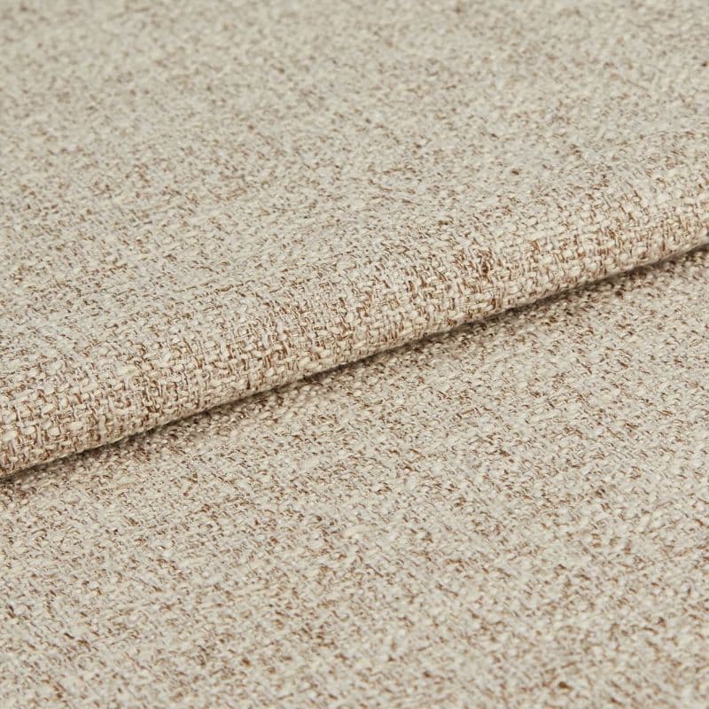 Beige woven upholstery fabric, densely textured and folded once; showing looped weave and subtle two-tone yarns, close-up on a neutral background under soft, even lighting.