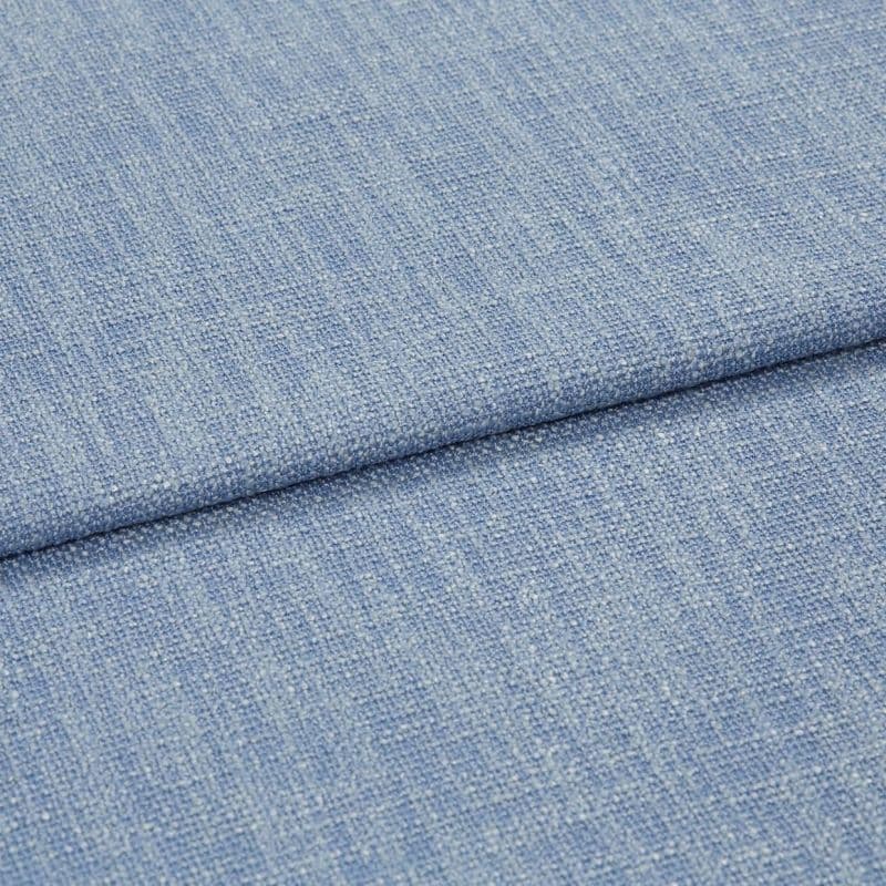 Blue woven upholstery fabric folded across the frame, showing a horizontal overlap and nubby textured weave; close-up shot with soft, even studio lighting and no background details.