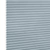 Light-blue cellular (honeycomb) blind, fully lowered with horizontal pleats and hexagonal cells visible at the left edge; blocking light in a close-up view against a white background.