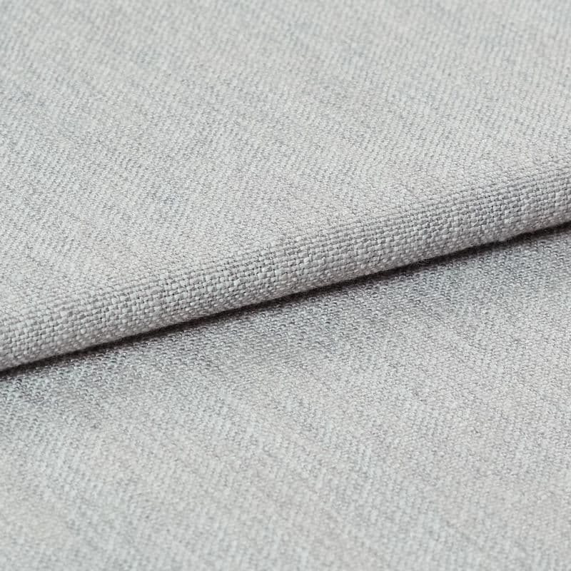 Light gray woven fabric, folded with a visible hem edge across the frame; tightly textured weave and subtle nap; close-up studio-lit shot on a neutral surface, soft even lighting.